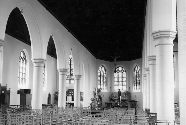 Het interieur van de kerk, met 3 wit bepleisterde en beschilderde beuken, geritmeerd door spitsbogen.
